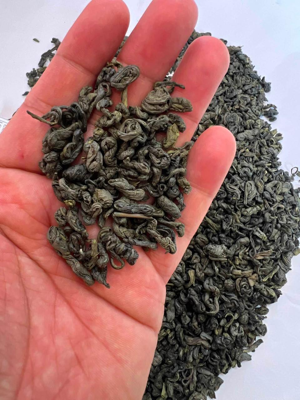 Close-up green tea leaves in hand